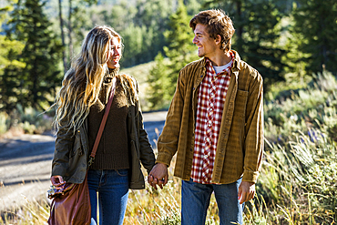 Smiling Caucasian couple holding hands outdoors