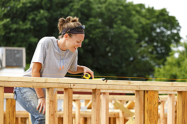 Caucasian woman measuring at construction site