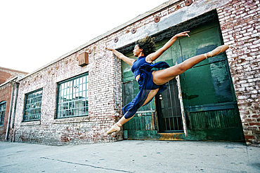 Mixed race woman dancing ballet in city