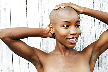 Close up of naked black woman rubbing bald head