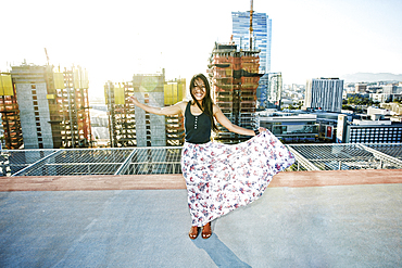 Asian woman dancing on urban rooftop