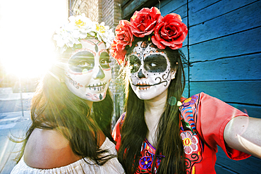 Women on sidewalk wearing skull face paint