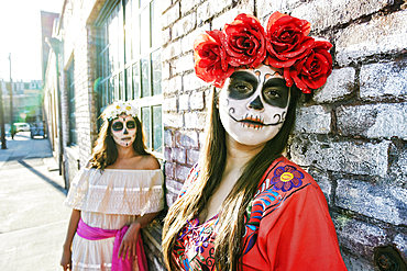 Women on sidewalk wearing skull face paint