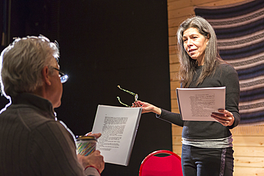 Hispanic man and woman reading scripts on theater stage