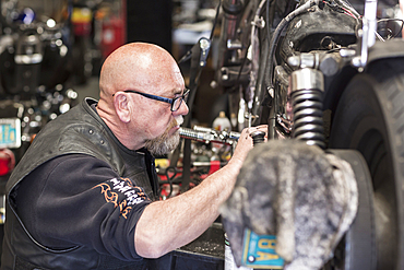 Caucasian man repairing motorcycle