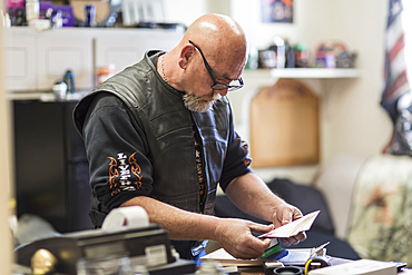 Caucasian man reading paperwork on clipboard