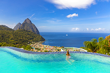 Caucasian girl swimming in infinity pool