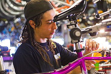 Man repairing bicycle in shop