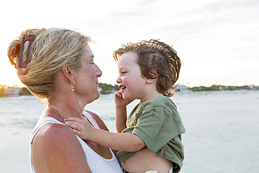 Caucasian mother holding boy at beach