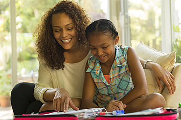 African American mother helping daughter with homework