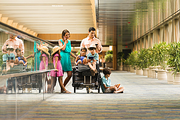 Family waiting in airport using cell phones