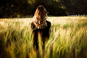 Caucasian woman standing in tall grass