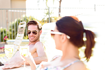 Caucasian couple relaxing in lounge chairs