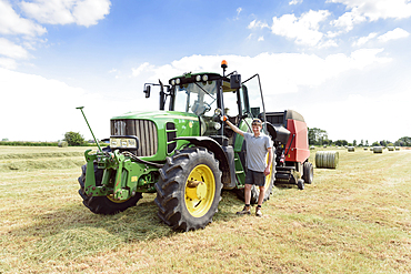 Confident Caucasian man standing near tractor