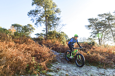 Caucasian woman riding bicycle on hill