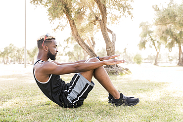 Black man doing sit-ups in park