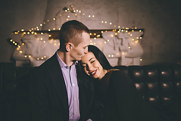 Caucasian man kissing forehead of woman