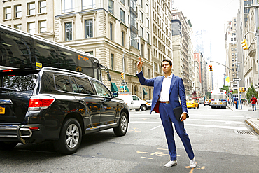 Caucasian businessman standing in street hailing taxi