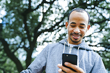 Black man listening to cell phone with earbuds