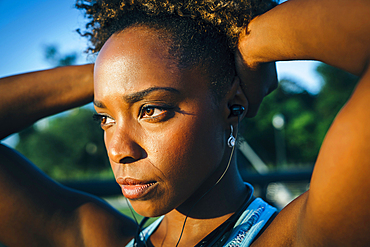 Close up of serious mixed race woman listening to earbuds