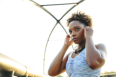 Mixed Race woman adjust earbuds