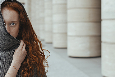 Caucasian woman hiding face behind hood