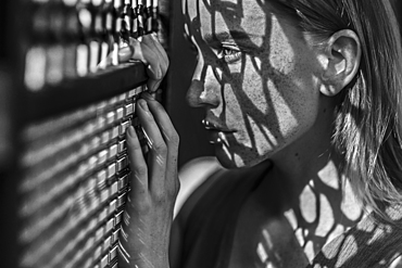 Caucasian woman with freckles leaning on window