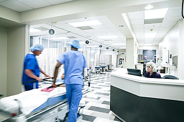 Doctors pushing patient in hospital gurney