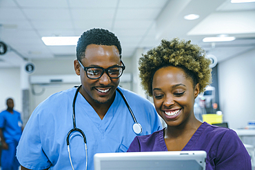 Smiling black nurses using digital tablet