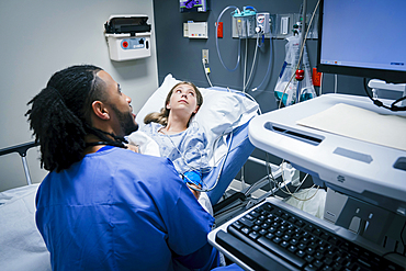 Nurse and patient looking at monitor in hospital