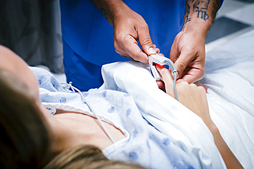 Nurse placing finger monitor on patient