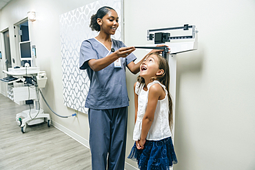 Nurse measuring height of girl