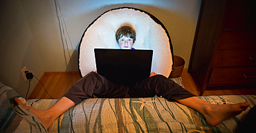 Caucasian boy with feet up using laptop