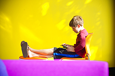 Caucasian boy relaxing and reading digital tablet