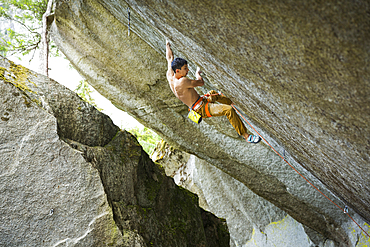 Mixed race boy rock climbing