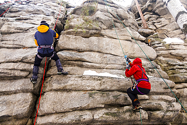 Caucasian man and woman rock climbing