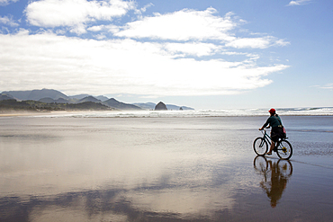 Caucasian woman riding bicycle on beach