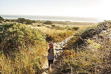 Caucasian girl walking on sandy path