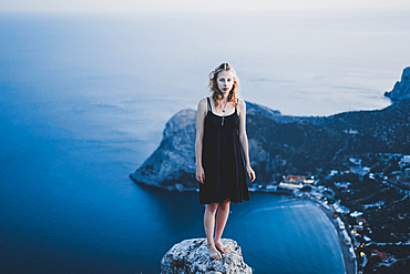 Caucasian woman standing on rock near ocean