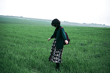 Caucasian woman standing in field of grass