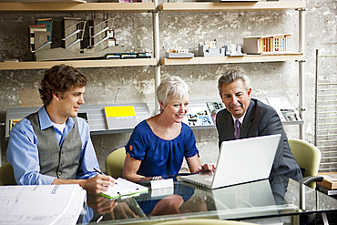 Business people using laptop in office