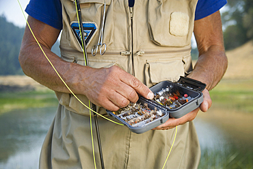 Caucasian man choosing fly for fishing