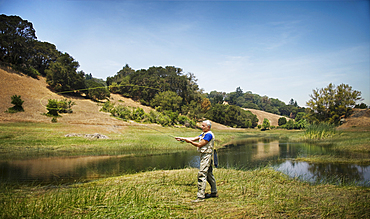 Caucasian man fishing at river