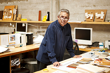 Portrait of serious Hispanic designer examining color swatches in office