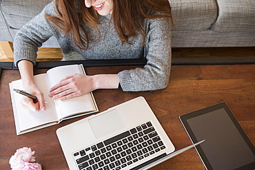 Caucasian woman writing in notebook