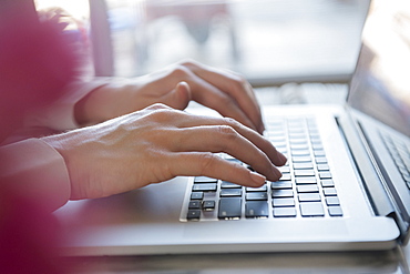 Hands of Caucasian woman typing on laptop