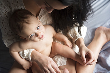 Caucasian mother holding baby son in lap