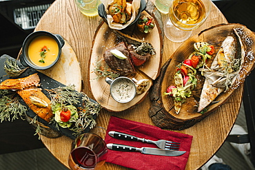 Variety of meat and fish on table with wine