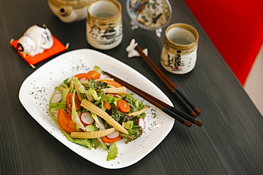 Chopsticks on the plate of salad