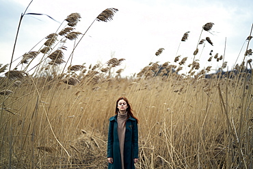 Caucasian woman standing in field with eyes closed